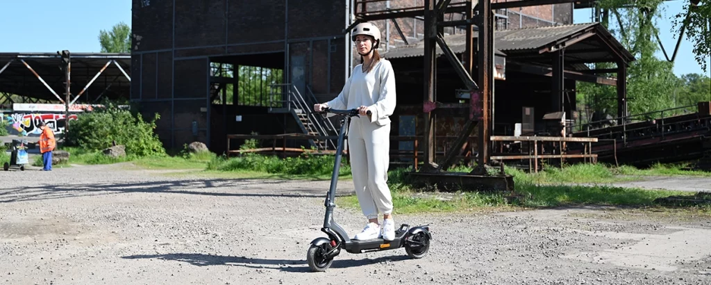 E-Scooter fahren lernen – 7 Tipps für Einsteiger 1 Trittbrett Fritz auf einer freien Fläche mit einer Fahranfängerin