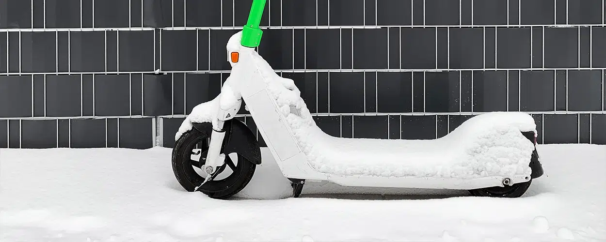 Ein elektrischer Roller ist mit Schnee bedeckt.