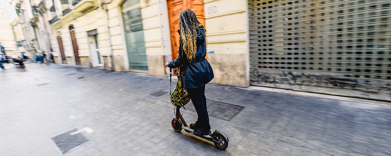 Frau fährt auf einem Elektroroller.