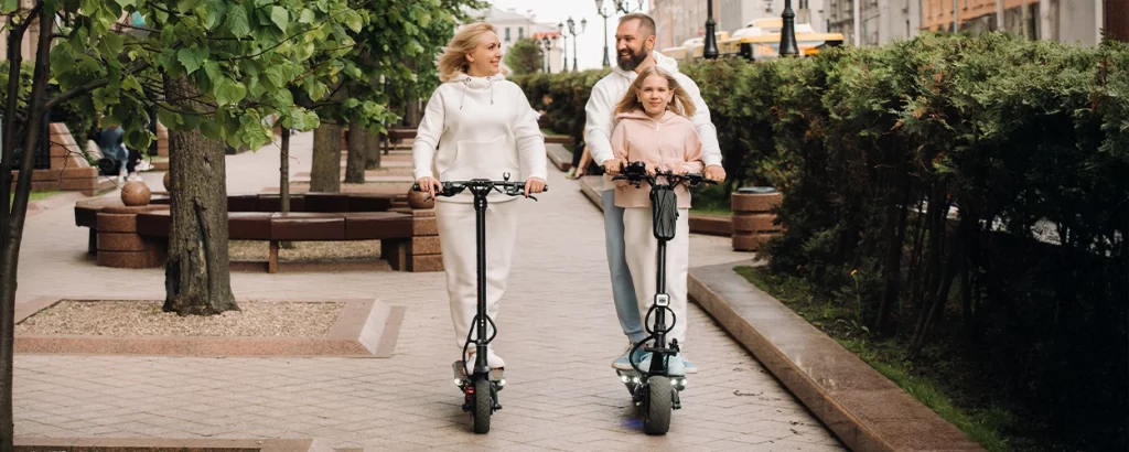 Eltern mit Kind auf E-Scooter