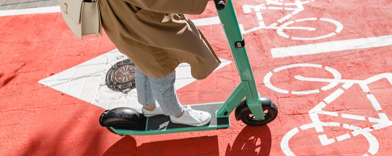 Frau auf einem Radweg mit einem E-Scooter