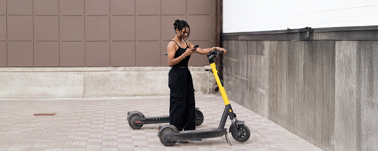 Frau mietet E-Scooter 7 Leih-Roller